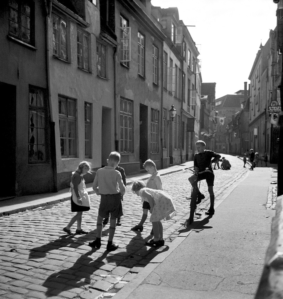 Roman Vishniac (America born Russia, 1897-1990) 'Children playing on a street lined with swastika flags' mid-1930s