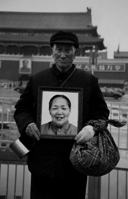 Hao Junchen. 'Hugging a portrait of his wife deceased wife, an elderly man fulfils their dream of visiting Beiijing' 2003 from the exhibition 'Humanism in China: A Contemporary Record of Photography' at the China Institute in America, New York, Sept - Dec, 2009