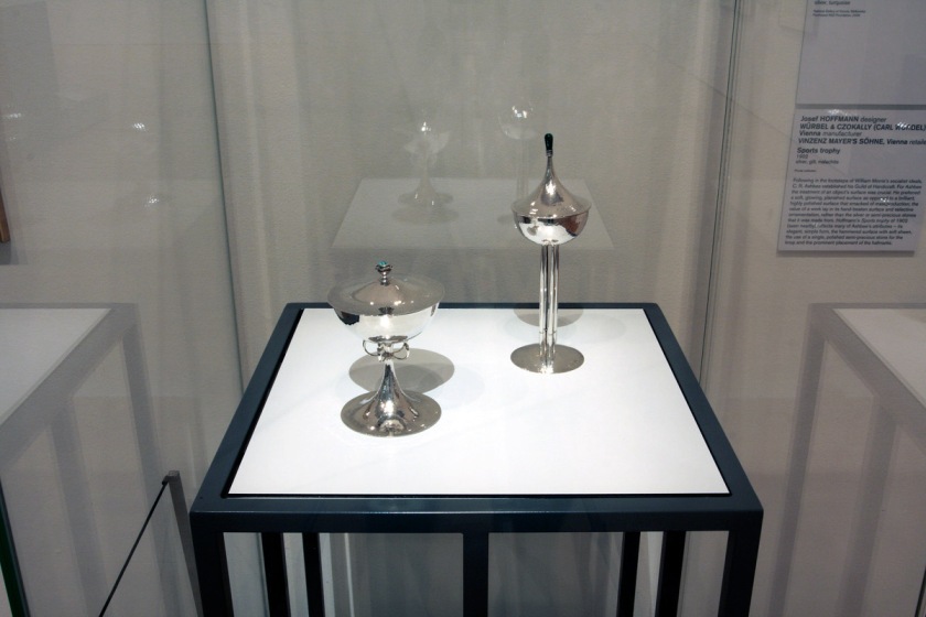 Charles Robert Ashbee designer 'Standing cup and cover' 1901 and Josef Hoffmann. ''Sports Trophy' 1902 (installation view)