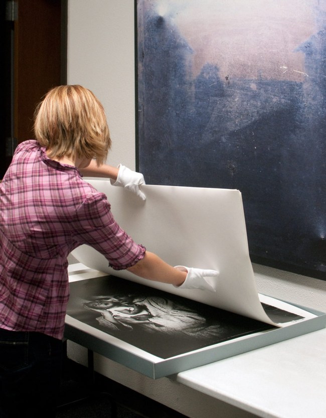 Archivist Amy Armstrong inspects a box from the archive of Magnum photographer Elliott Erwitt. 