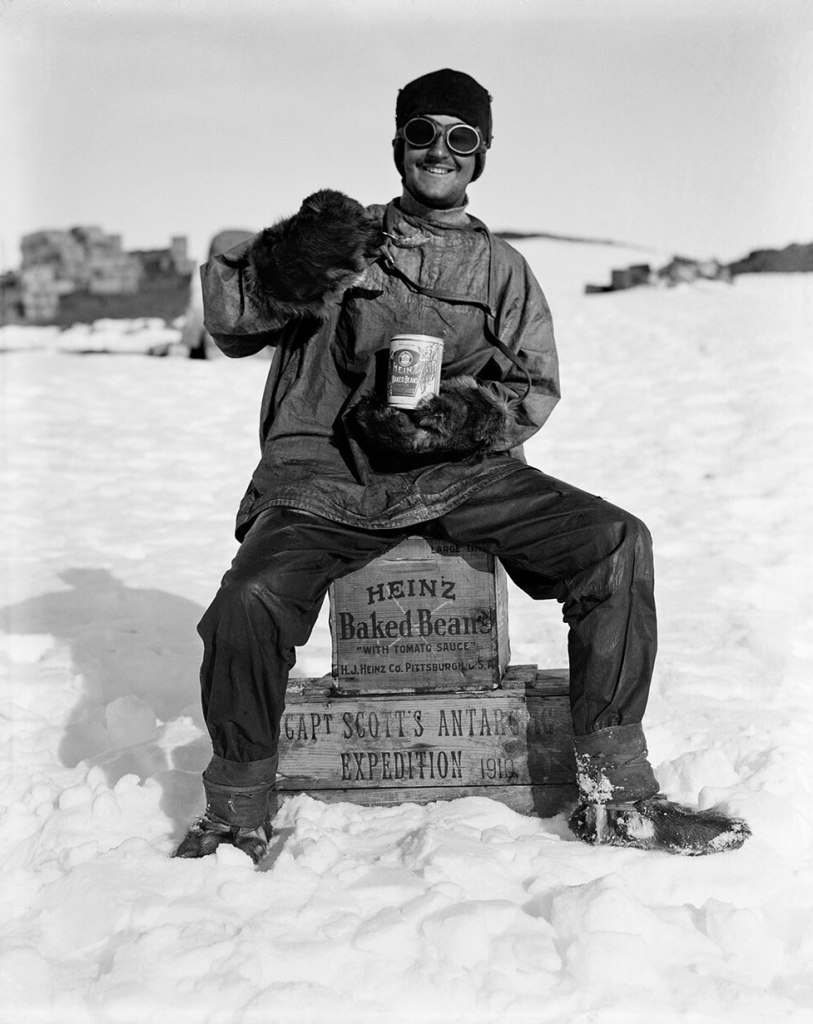 Herbert Ponting (British, 1870-1935) 'A member of the team tucks into a tin of Heinz baked beans in the Ross Dependency, during Captain Robert Falcon Scott’s Terra Nova Expedition to the Antarctic, January 1912' 1912