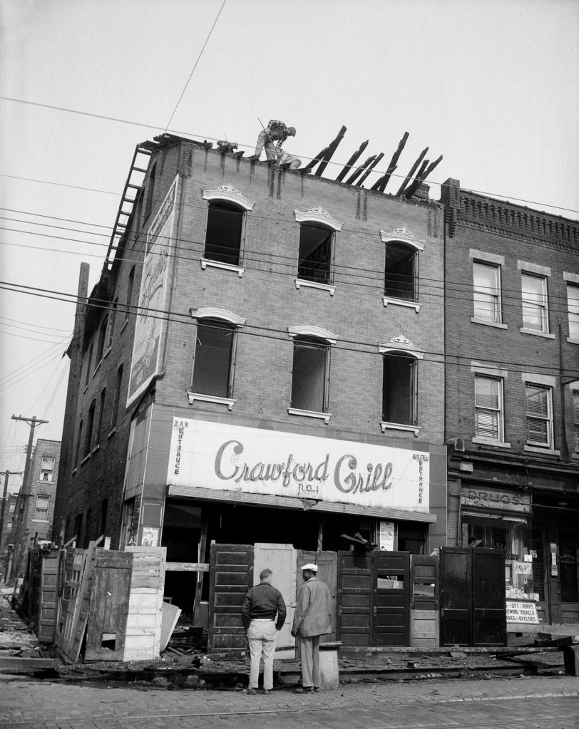 Teenie Harris (American, 1908-1998) 'Workers demolishing roof of Crawford Grill No. 1, 1401 Wylie Avenue at Townsend Street, Hill District' 1956