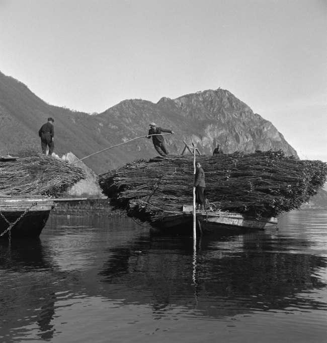 Anonymous photographer. 'Using boats to transport wood and stone on Lake Lugano' 1940. © Swiss National Museum 