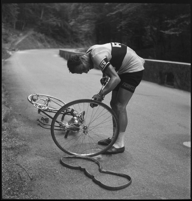 Anonymous photographer. 'Walter Diggelmann repairs a tyre during the Tour de Suisse' 1950