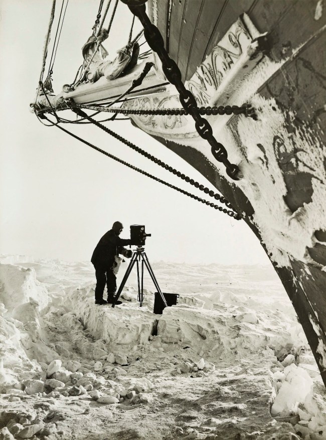 Frank Hurley (Australian, 1885-1962) 'Self-portrait with cinematograph next to the Endurance' 1915