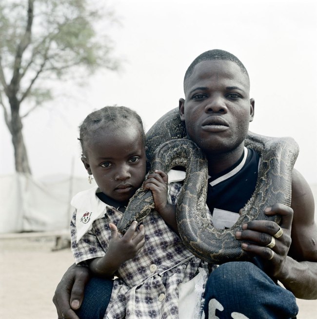 Pieter Hugo (South African, b. 1976) 'Mummy Ahmadu and a snake charmer with a rock python, Abuja' From the series 'The Hyena & Other Men' 2005-2007