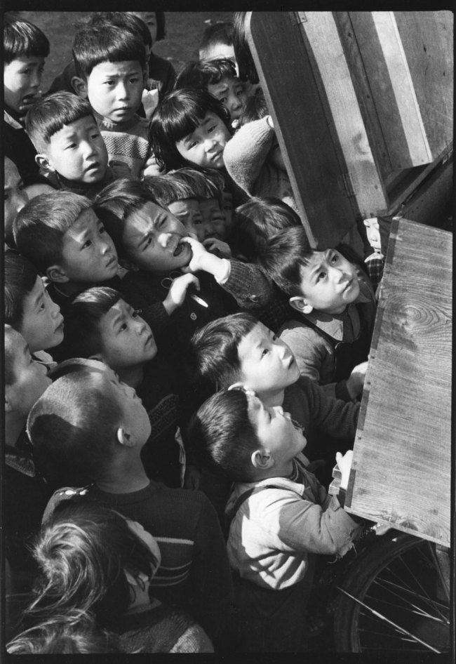 Ken Domon (Japanese, 1909-1990) 'Children looking at a picture-card show' Tokyo 1953
