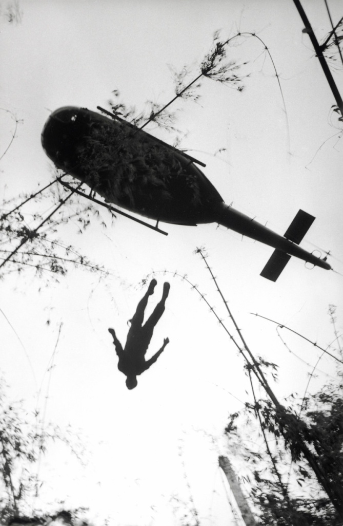 Henri Huet, French (1927-1971) 'The body of an American paratrooper killed in action in the jungle near the Cambodian border is raised up to an evacuation helicopter, Vietnam' 1966