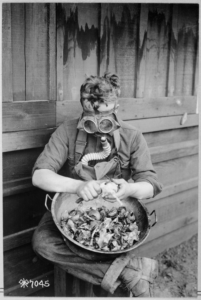 Anonymous photographer. 'Soldiers trying out their gas masks in every possible way. Putting the respirator to good use while peeling onions. 40th Division, Camp Kearny, San Diego, California' 1918
