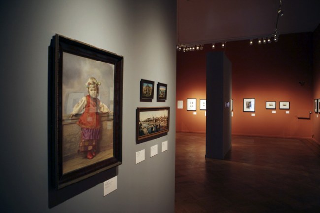 Installation photograph of the exhibition 'Primrose - Russian Colour Photography' at Foam, Amsterdam showing at left, Elena Mrozovskaya's 'Portrait of girl in Little Russia costume. Saint Petersburg' (1900s)