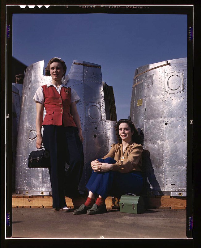 Alfred Palmer (American, 1906-1993) 'Two assembly line workers at the Long Beach, Calif., plant of Douglas Aircraft Company enjoy a well-earned lunch period, Long Beach, Calif. Nacelle parts of a heavy bomber form the background' October 1942