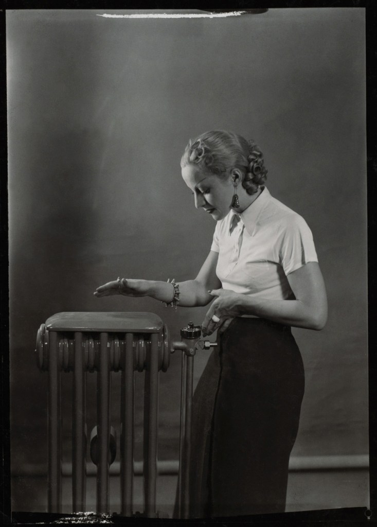 Éditions Paul Martial, Paris. 'Woman posing next to radiator, advertising photography for "Gaz et Eaux"' April 1936
