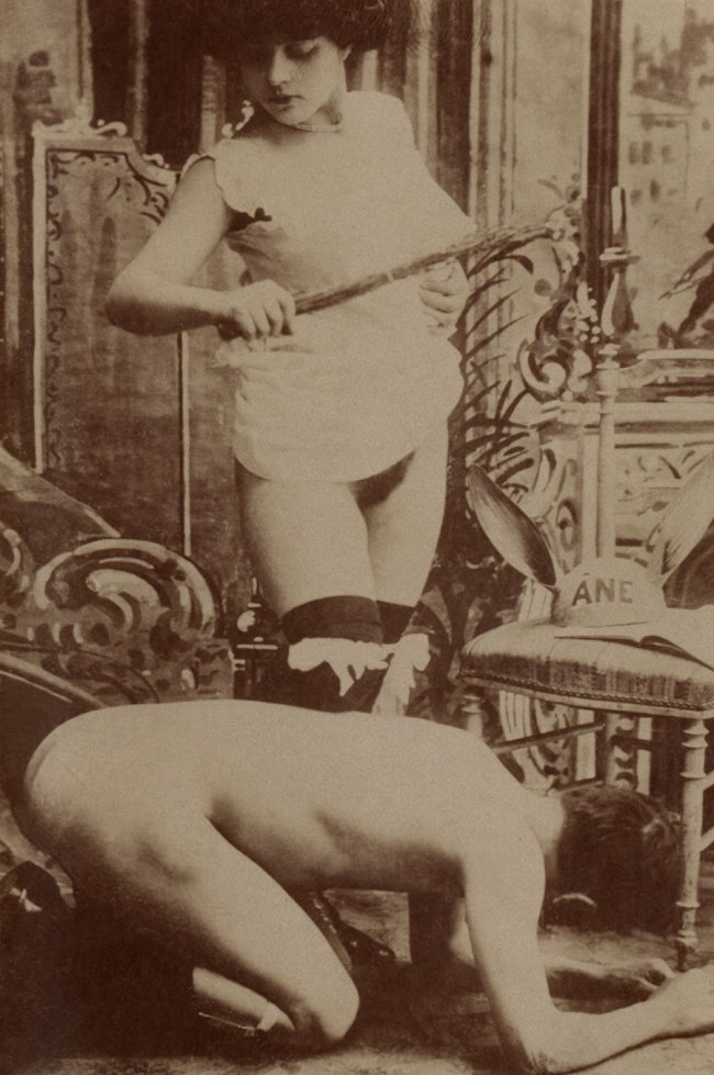 Unknown photographer (France) 'Woman holding a birch rod over a kneeling nude man' 1890-1900