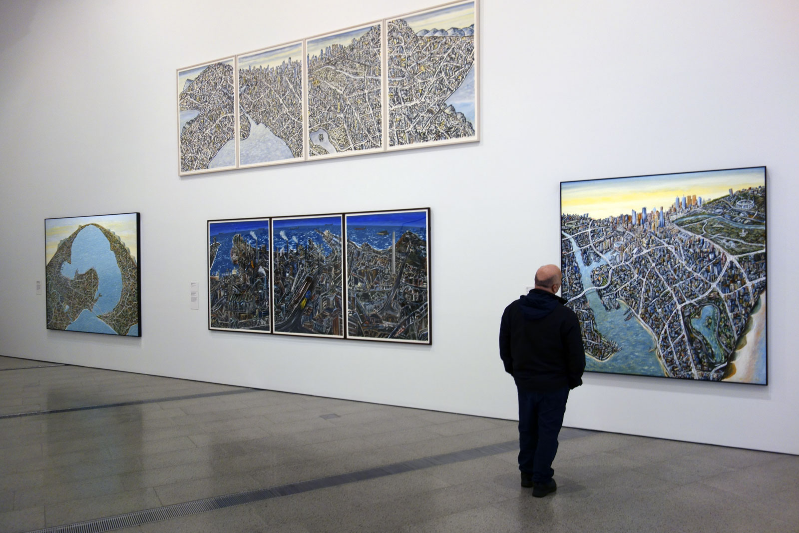 Installation view of the exhibition Jan Senbergs: Observation – Imagination at The Ian Potter Centre: NGV Australia showing at top, 'Extended Melbourne labyrinth' (2013, above); at left, 'Geelong capriccio (if Geelong were settled instead of Melbourne)' (2010, above); at right 'Melbourne capriccio 3'