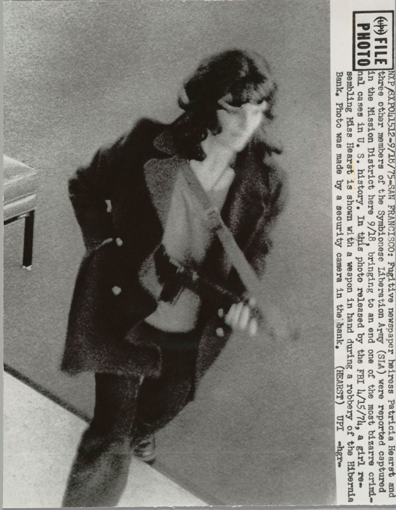 United Press International (American) Person in Photograph: Patricia Hearst (American, born 1954) 'SAN FRANCISCO. Fugitive newspaper heiress Patricia Hearst and three other members of the Symbionese Liberation Army (SLA) were reported captured in the Mission District here 9/18, bringing to an end one of the most bizarre criminal cases in U.S. History. In this photo released by the FBI 4/15/74, a girl resembling Miss Hearst is shown with a weapon in hand during a robbery of the Hibernia Bank' 1974