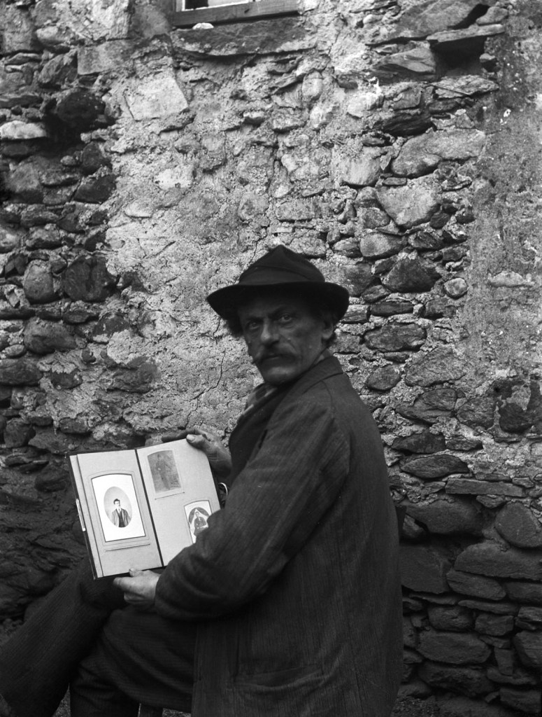 Roberto Donetta (Swiss, 1865-1932) 'Self-portrait of Roberto Donetta with hat and a photo album in hand, in front of a wall, Bleniotal' 1900-1932