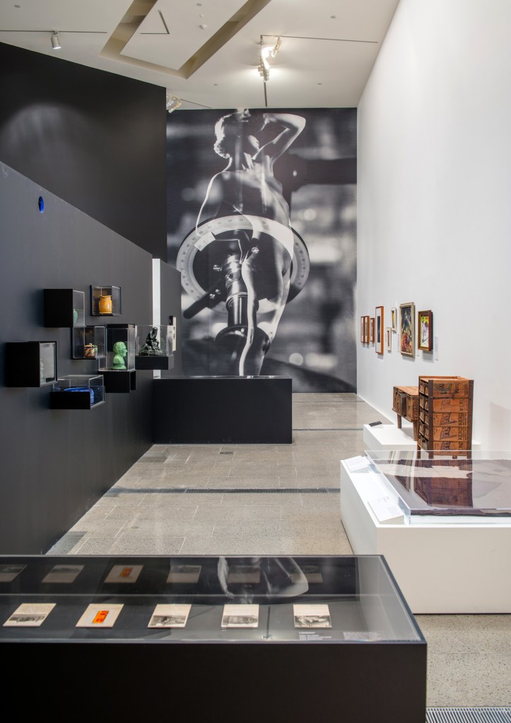 Installation view of the exhibition 'Brave New World: Australia 1930s' at NGVA with Max Dupain's 'Brave New World' (wall print) at centre rear with Sideboard and Chest of drawers at right