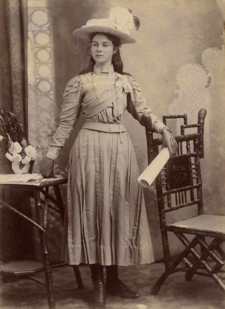 James Patching & Co., 'Young lady in feathered hat leaning on bamboo furniture' 1897-1901