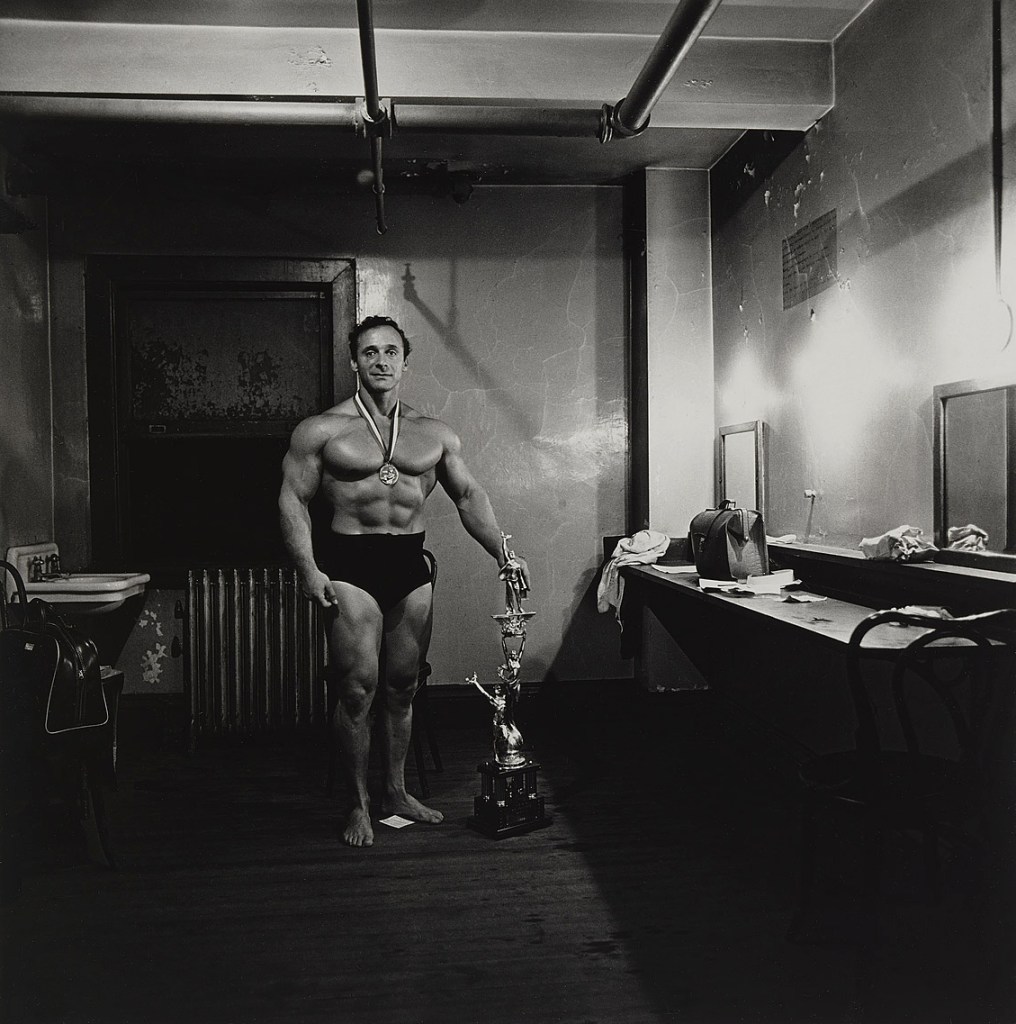 Diane Arbus (American, 1923-1971) 'Muscle Man in his dressing room with trophy, Brooklyn, N.Y.' 1962