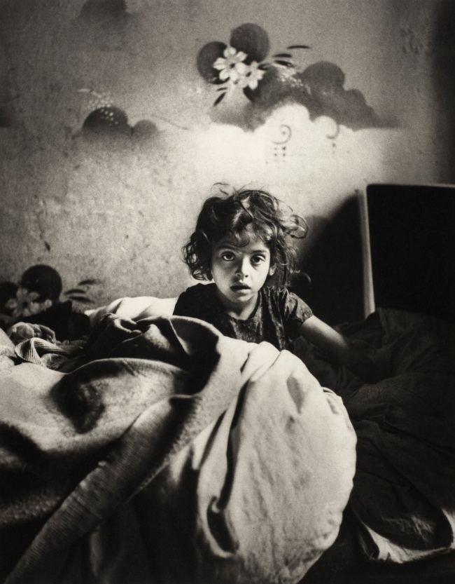 Roman Vishniac (1897-1990) 'Sara, sitting in bed in a basement dwelling, with stencilled flowers above her head, Warsaw' c. 1935-1937