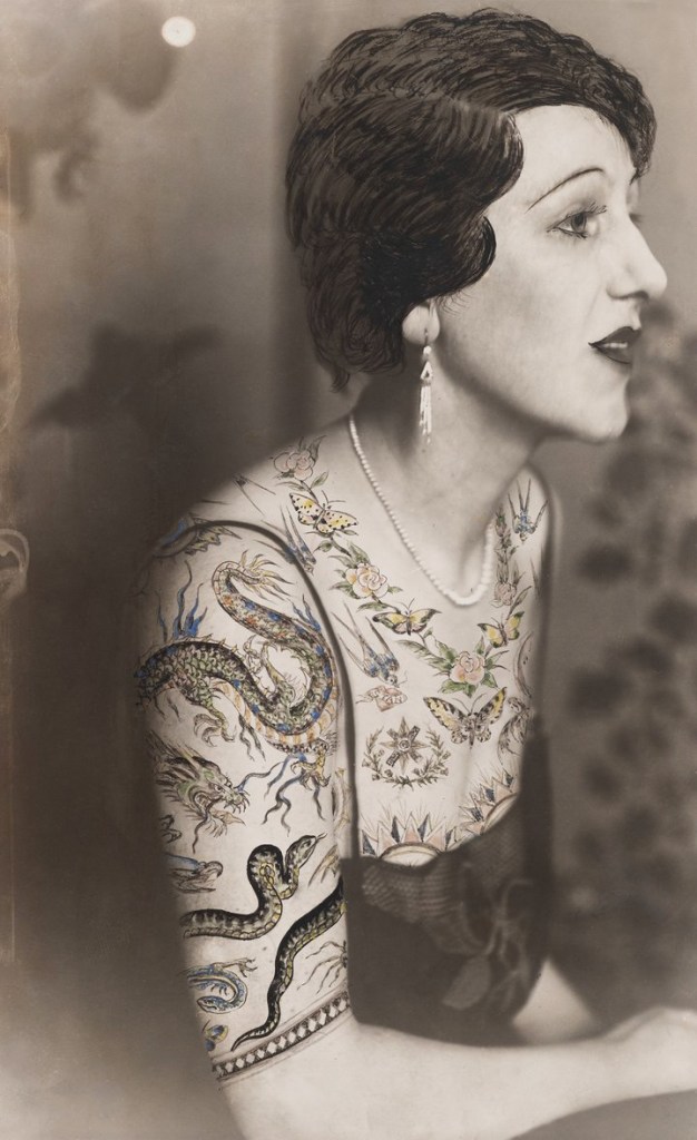 Dora Maar (French, 1907-1997) 'Woman sitting in profile, the bust dressed in a blouse made of tattoo patterns drawn on the photograph' c. 1930 from the exhibition 'Dora Maar' at Tate Modern, London, November 2019 - March 2020 Dora Maar (French, 1907-1997) 'Woman sitting in profile, the bust dressed in a blouse made of tattoo patterns drawn on the photograph' c. 1930 from the exhibition 'Dora Maar' at Tate Modern, London, November 2019 - March 2020