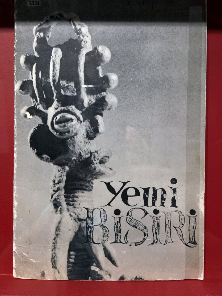 Installation view of the exhibition 'Into the Night: Cabarets and Clubs in Modern Art' at the Barbican Art Gallery showing some of the publishing output of the Mbari clubs Installation view of the exhibition 'Into the Night: Cabarets and Clubs in Modern Art' at the Barbican Art Gallery showing some of the publishing output of the Mbari clubs
