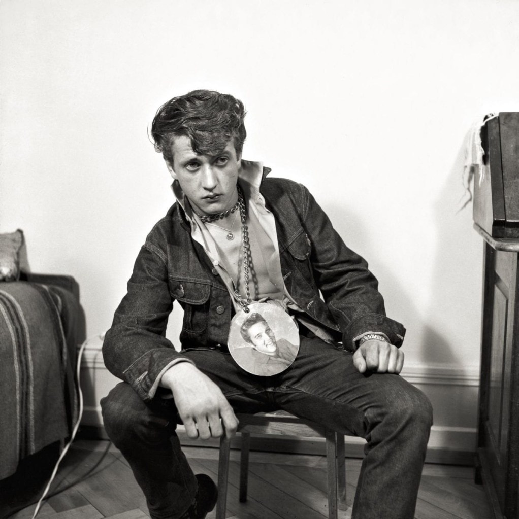 Karlheinz Weinberger (Swiss, 1921-2006) 'Sitting boy with elvis necklace in KHW studio, Zurich' 1961 Karlheinz Weinberger (Swiss, 1921-2006) 'Sitting boy with elvis necklace in KHW studio, Zurich' 1961