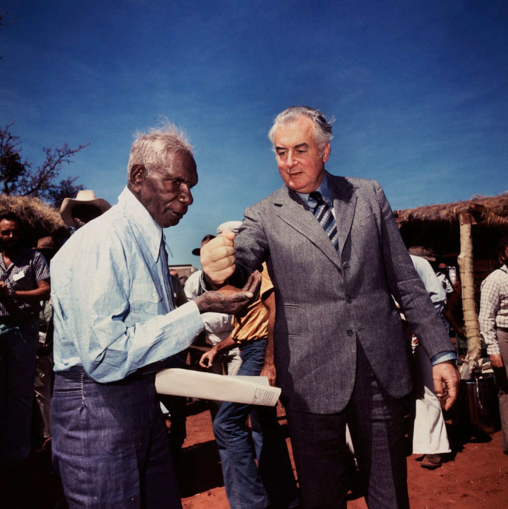 Mervyn Bishop (Australian, b. 1945) 'Prime Minister Gough Whitlam pours soil into the hands of traditional land owner Vincent Lingiari, Northern Territory' 1975, printed 1999 from the exhibition 'Mervyn Bishop: Australian Photojournalist' at the National Film and Sound Archive of Australia, Acton, Canberra ACT, march - Oct, 2021