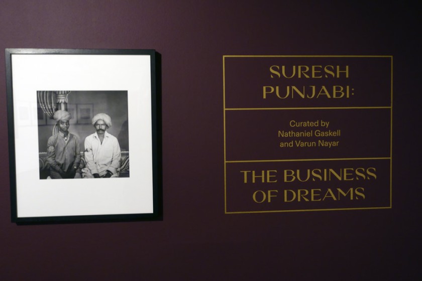 Installation view of the opening of the exhibition 'Visions of India: from the colonial to the contemporary' at the Monash Gallery of Art showing at left, Suresh Punjabi's 'Untitled (Two train porters, Behru Singh and his son Laxman)' (Nd)