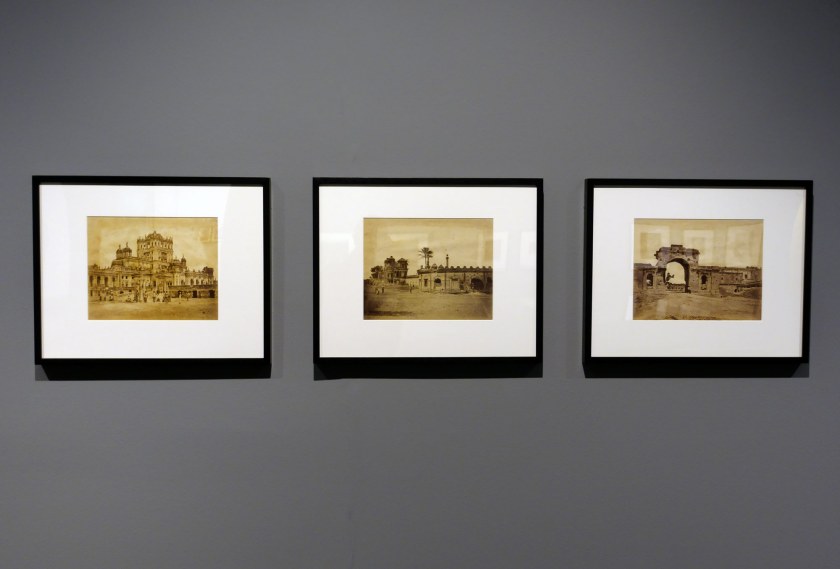 Installation view of the exhibition 'Visions of India: from the colonial to the contemporary' at the Monash Gallery of Art showing photographs by Felice Beato (Italian, 1832-1909) with at left, 'Kaiser Bagh' (1857); at centre, 'The Secundra Bagh', showing the breach and gateway, first attack of Sir Colin Campbell in November (1858); and at right, 'Gateway leading into the residency held by Captain Atkinson, 13th Native Infantry, commonly called the Bailee Guard Gate' (1858)