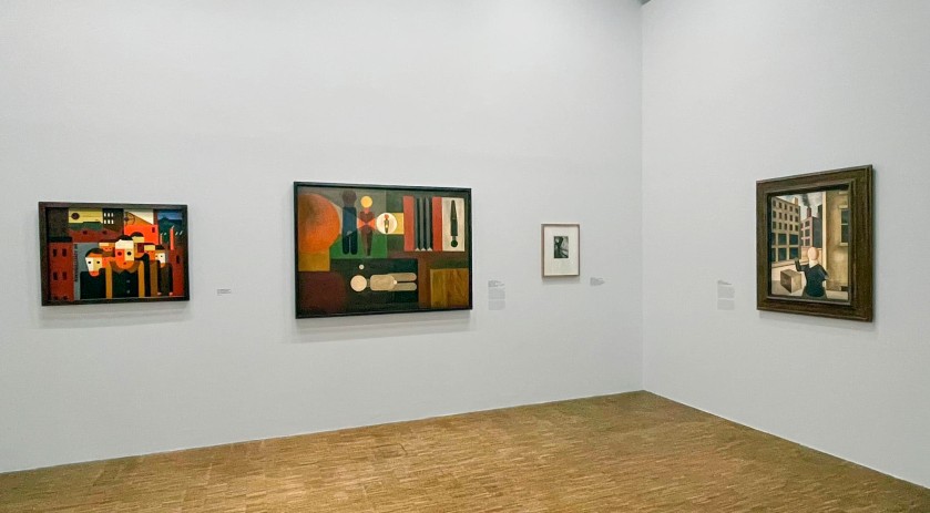 Installation view of the exhibition 'Germany / 1920s / New Objectivity / August Sander' at Centre Pompidou, Paris showing at second left, Franz Wilhelm Seiwert's 'Wandbild für einen Fotografen' (Mural for a Photographer) (1925); and at right, George Grosz's 'Konstruktion (Ohne Titel)' (1920)