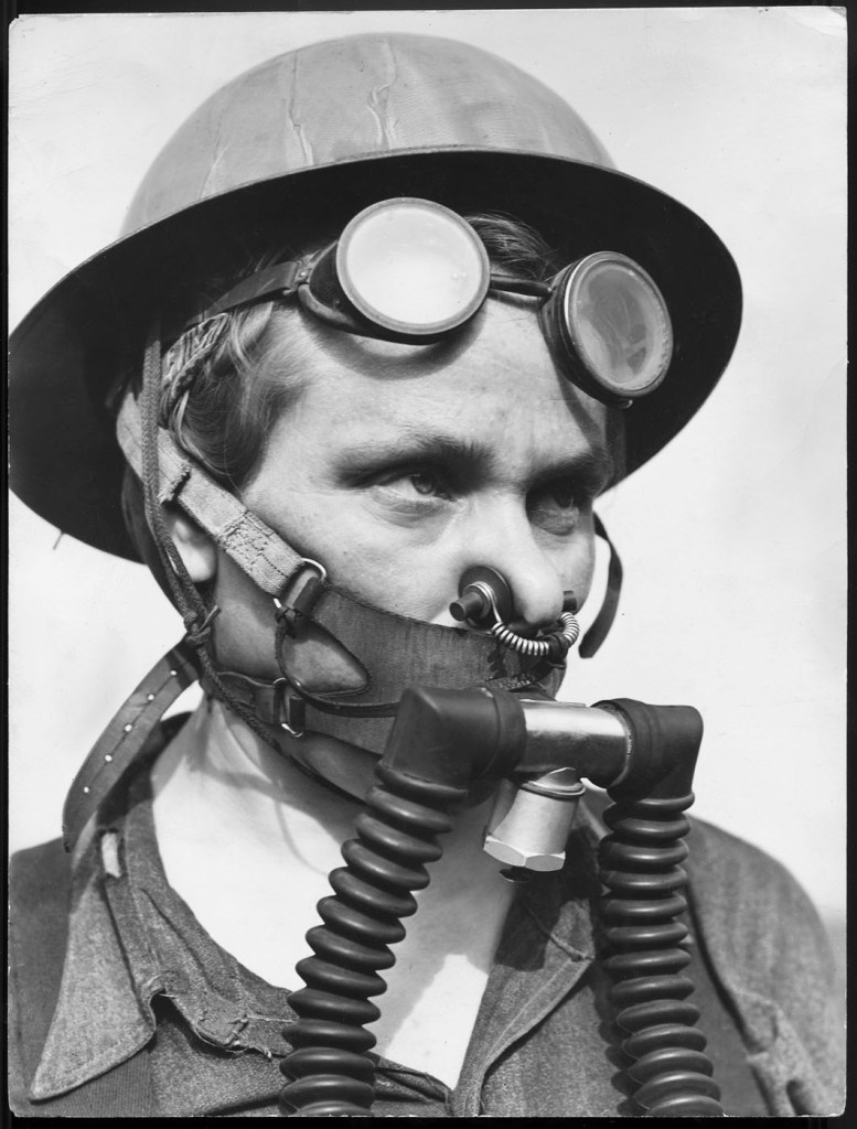 Margaret Bourke‑White (American, 1904-1971) 'Blast furnace cleaner Bernice Daunora, part of the top gang at Carnegie‑Illinois Steel Corp., wearing protective breathing apparatus fr. escaping gas fumes' 1943