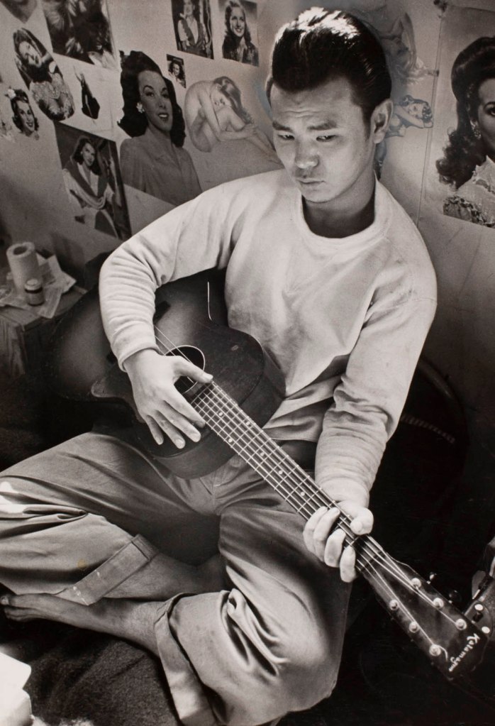 Carl Mydans (American, 1907-2004) '(Young man playing guitar in the stockade, Tule Lake Internment Camp, Newell, California)' 1944