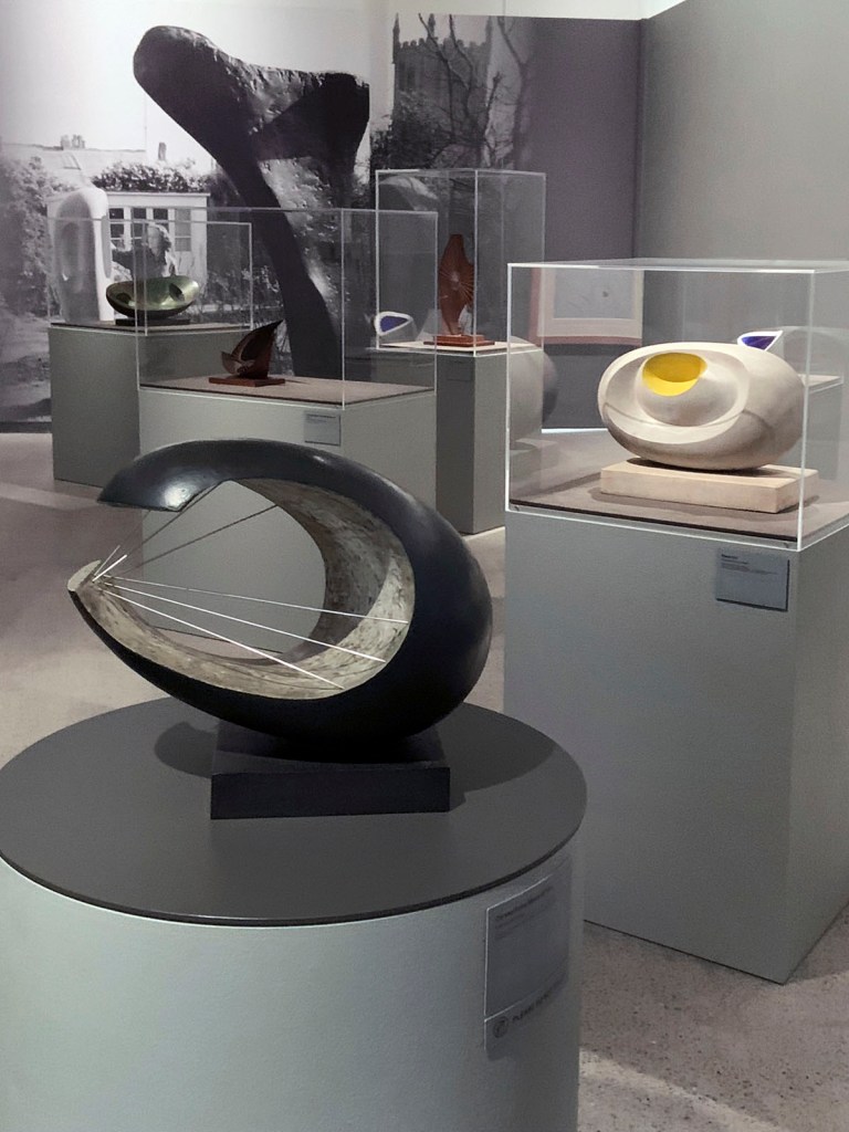 Installation view of the exhibition 'Barbara Hepworth: In Equilibrium' at the Heide Museum of Modern Art, Melbourne showing at left 'Curved Form (Wave II)' 1959; and at right 'Eidos' 1947