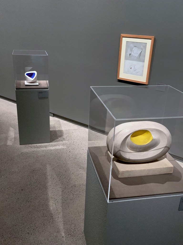 Installation view of the exhibition 'Barbara Hepworth: In Equilibrium' at the Heide Museum of Modern Art, Melbourne showing at left 'Sculpture with Colour (Deep Blue and Red) [6]' 1940; and at right 'Eidos' 1947