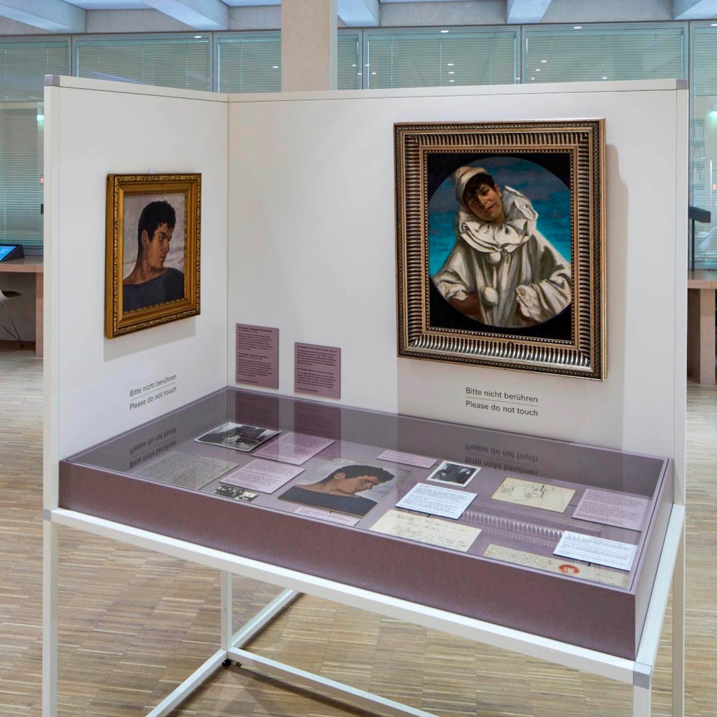 Installation view of the exhibition 'TO BE SEEN: Queer Lives 1900-1950' at the Munich Documentation Center for the History of National Socialism showing at left on the wall, Paul Hoecker's painting 'Head of a youth / Portrait of a boy' (1901); and at right on the wall, Paul Hoecker's painting 'Pierrot' (Nd) Installation view of the exhibition 'TO BE SEEN: Queer Lives 1900-1950' at the Munich Documentation Center for the History of National Socialism showing at left on the wall, Paul Hoecker's painting 'Head of a youth / Portrait of a boy' (1901); and at right on the wall, Paul Hoecker's painting 'Pierrot' (Nd)