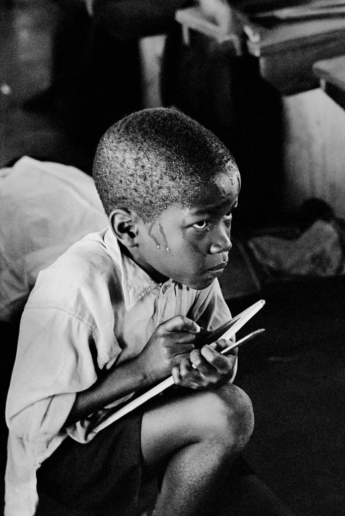Ernest Cole (South African, 1940-1990) 'Earnest boy squats on haunches and strains to follow lesson in heat of packed classroom, South Africa' 1960-1966 from the exhibition 'Ernest Cole: House of Bondage' at Foam, Amsterdam, Jan - June, 2023