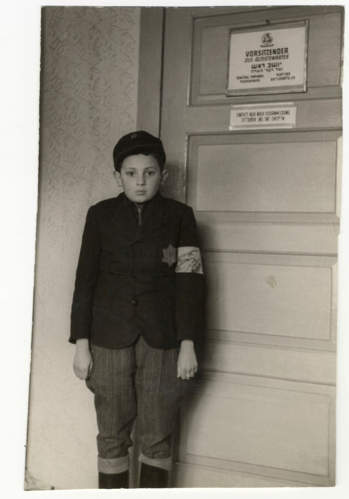 Unknown photographer. 'The child Jacob Bergman standing at the entrance to the office of the "Judenrat" Chairman, Dr. Elchanan Elkes' Ghetto Kovno, Nd from the exhibition 'Flashes of Memory. Photography During the Holocaust' at the Museum für Fotografie, Berlin, March - August, 2023