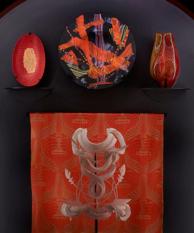 Installation view detail of the exhibition '1,001 Remarkable Objects' at Powerhouse Ultimo, Sydney showing at top left, Bowl, murrine opache, Carlo Scarpa for VSM Paolo Venini & Co, Murano, Venice, Italy, c. 1940; at top centre, Bowl form, Untitled, kiln formed fused mosaic glass, designed and made by Klaus Moje, Canberra, Australian Capital Territory, Australia, 1990-1991; at top right, Vase, blown glass with cane inclusions, Lino Tagliapietra, Rozelle, New South Wales, Australia, 1997; and at centre back, Textile length, Mohnkopfe (poppy heads), silk-double weave, Art Nouveau style, woven by Johann Backhausen and Sohne, Vienna, Austria, made by Koloman Moser, Vienna, Austria, 1900-1903