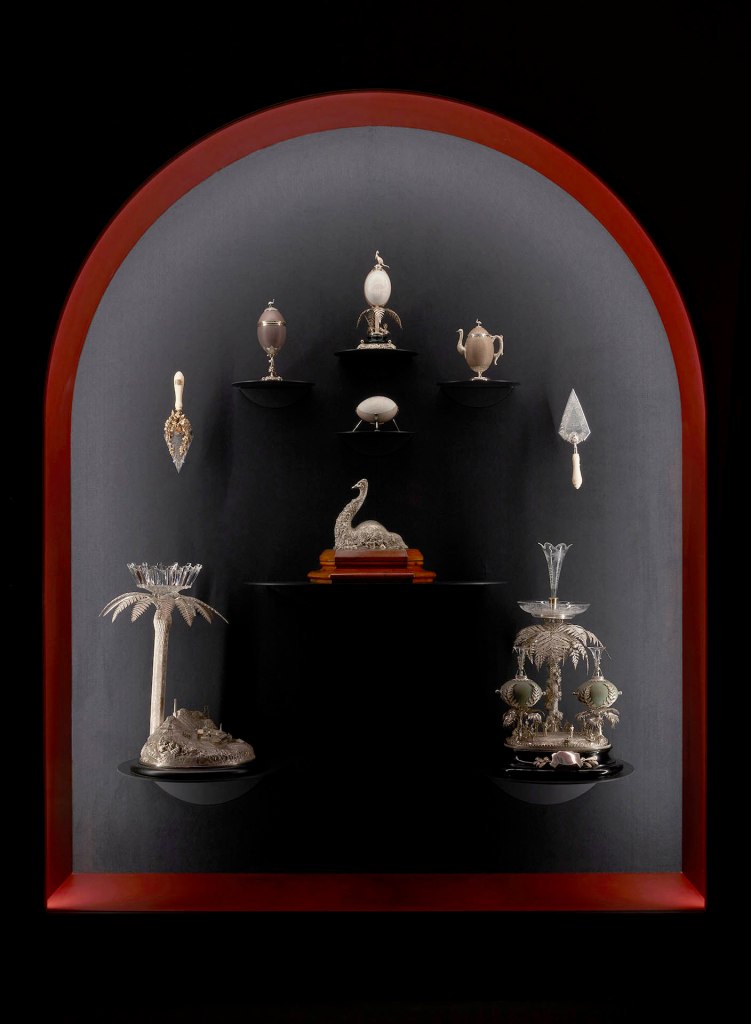 Installation view of the exhibition '1,001 Remarkable Objects' at Powerhouse Ultimo, Sydney showing numerous examples of Australian colonial silver in the Powerhouse Collection including at centre, Evan Jones' Inkstand, seated emu form (c. 1875)