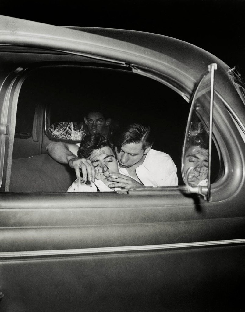 Weegee (American, 1899-1968) 'Untitled [Young man smoking cigarette in crashed car while waiting for ambulance, New York]' 1941