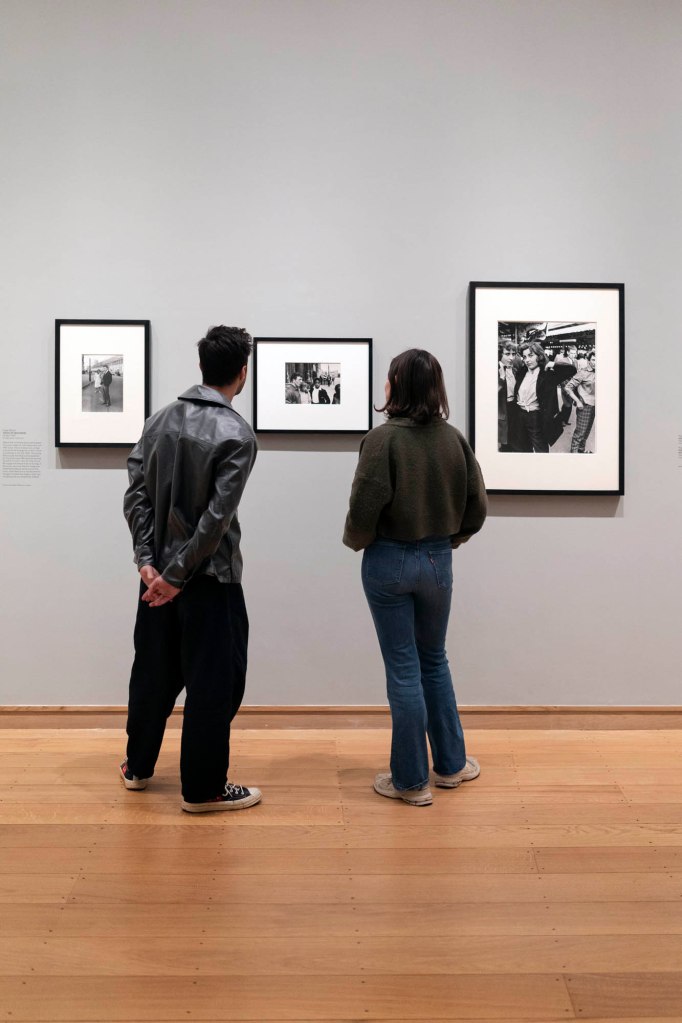 Installation view of the exhibition 'Roger Mayne: Youth' at the Courtauld Gallery, London showing at left, Mayne's 'Teenage Couple, Absolute Beginners photo-shoot' (26 April 1959); at centre, 'Men and boys, Southam Street, London' (1959); and at right, 'Teddy Girls, Battersea Funfair' (1956)