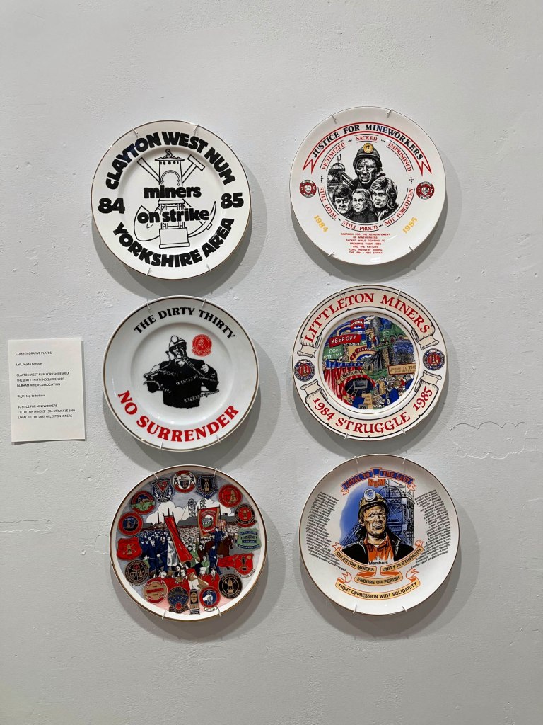 Installation view of the exhibition ONE YEAR! Photographs from the Miners' Strike 1984-85 at Four Corners, London showing closed colliery commemorative plates