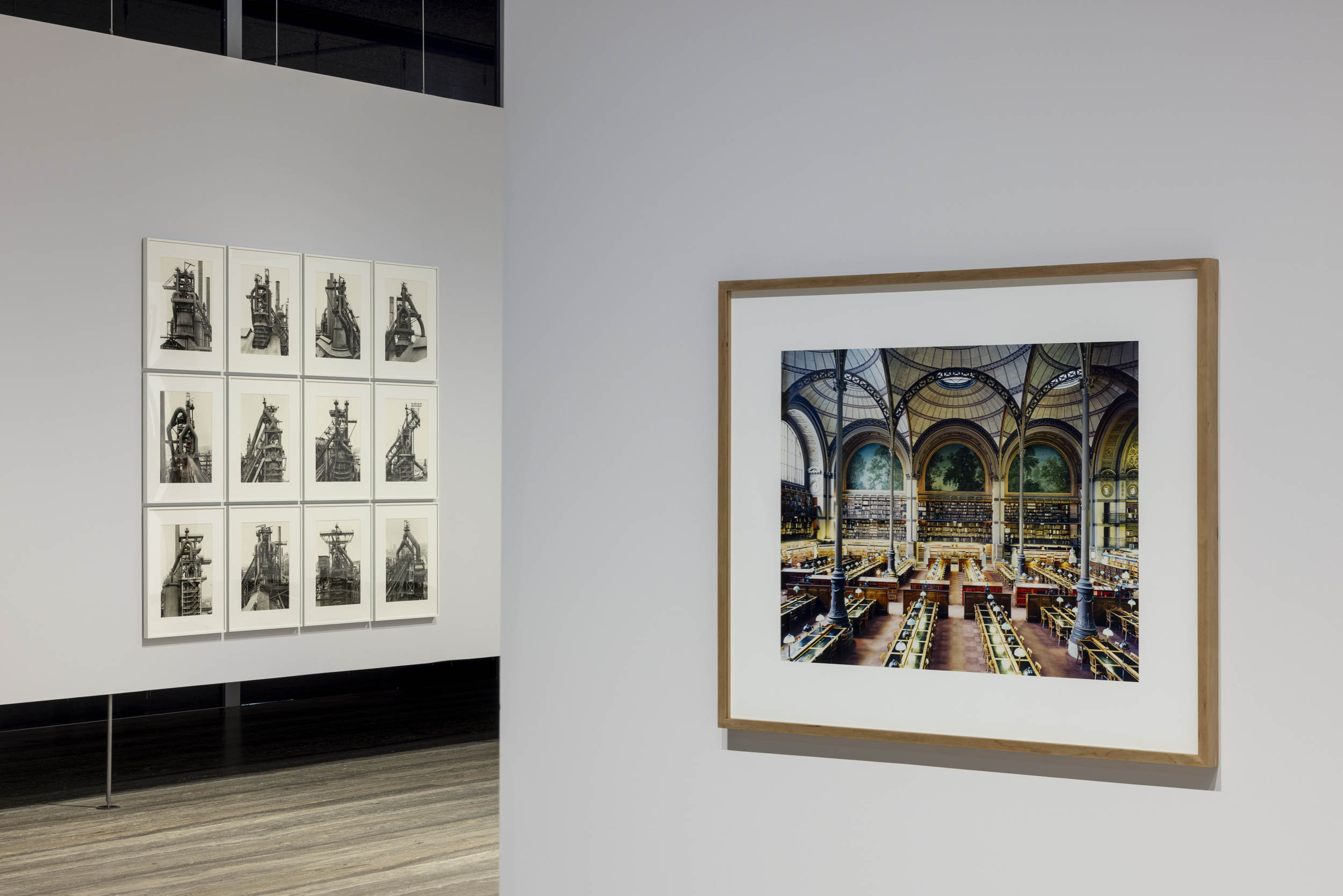 Installation view of the exhibition 'Typologien: Photography in 20th-century Germany' at Fondazione Prada, Milan showing at left Bernd and Hiller Becher's 'Hochöfen' (Blast furnaces) 1970-1989; and at right, Candida Höfer's 'Bibliotheque Nationale de France XXIII' 1997 Installation view of the exhibition 'Typologien: Photography in 20th-century Germany' at Fondazione Prada, Milan showing at left Bernd and Hiller Becher's 'Hochöfen' (Blast furnaces) 1970-1989; and at right, Candida Höfer's 'Bibliotheque Nationale de France XXIII' 1997