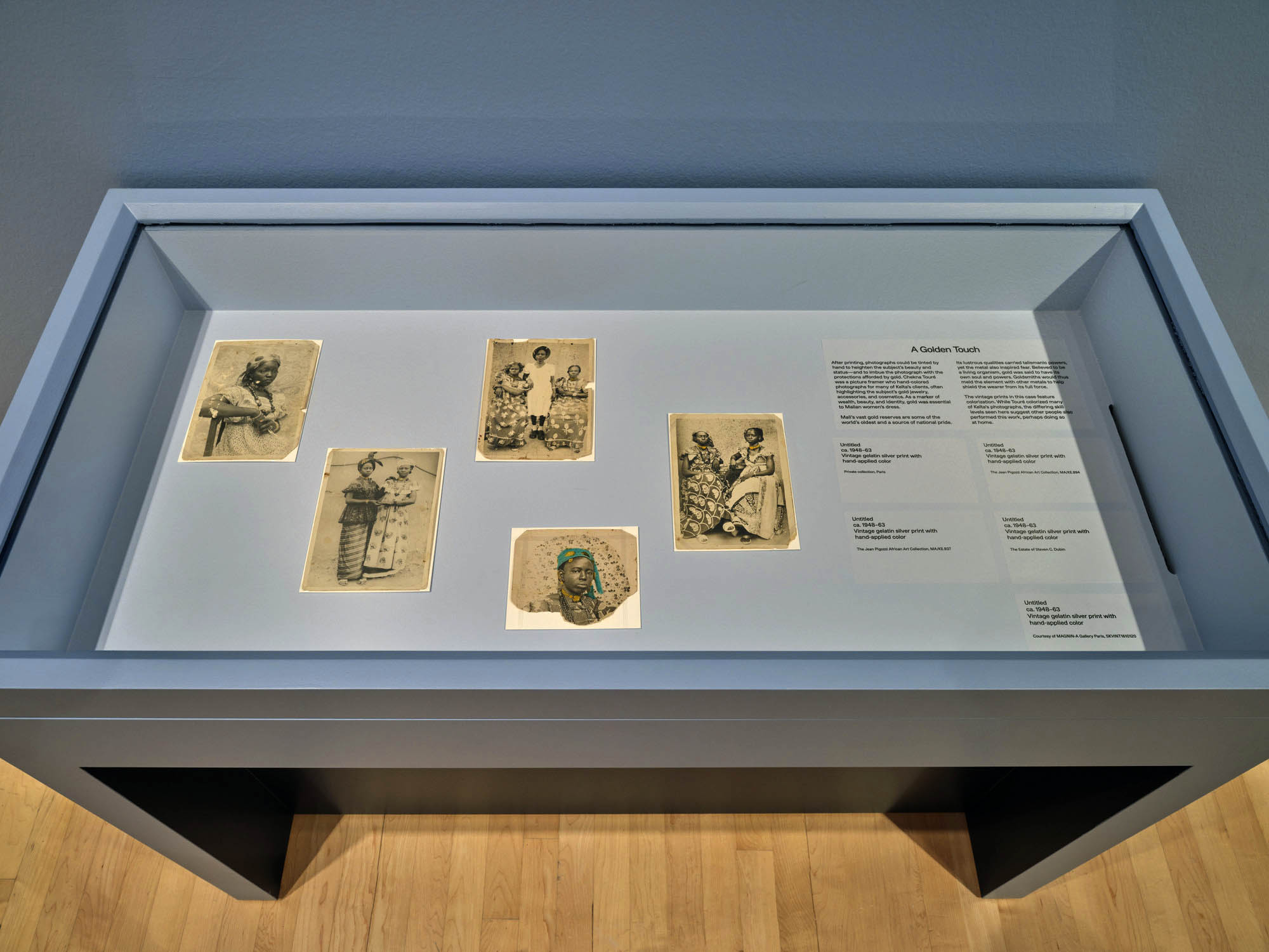 Installation view of the exhibition 'Seydou Keïta: A Tactile Lens' at the Brooklyn Museum, New York, October 2025 - May 2026 showing text from the section "A Golden Touch" with at bottom centre, Keïta's photograph 'Untitled' c. 1948-1963 Installation view of the exhibition 'Seydou Keïta: A Tactile Lens' at the Brooklyn Museum, New York, October 2025 - May 2026 showing text from the section "A Golden Touch" with at bottom centre, Keïta's photograph 'Untitled' c. 1948-1963