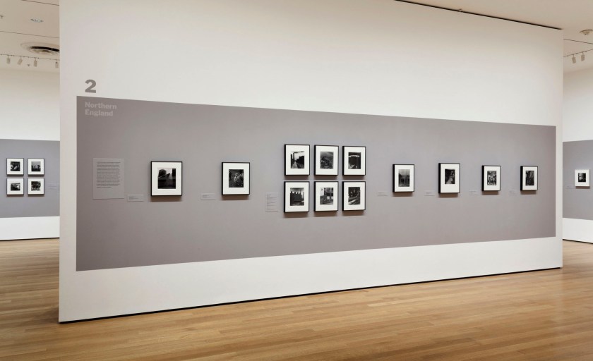 Installation view of the exhibition 'Bill Brandt: Shadow and Light' at The Museum of Modern Art, New York, March - August, 2013 showing photographs from the section "Northern England" including at left, Brandt's 'A Snicket in Halifax' (1937); at third right, 'Coal-Searcher Going Home to Jarrow' (1937); at second right, 'Northumbrian Miner at His Evening Meal' (1937); and at right, 'East Durham Coal-Miner Just Home from the Pit' (1937)