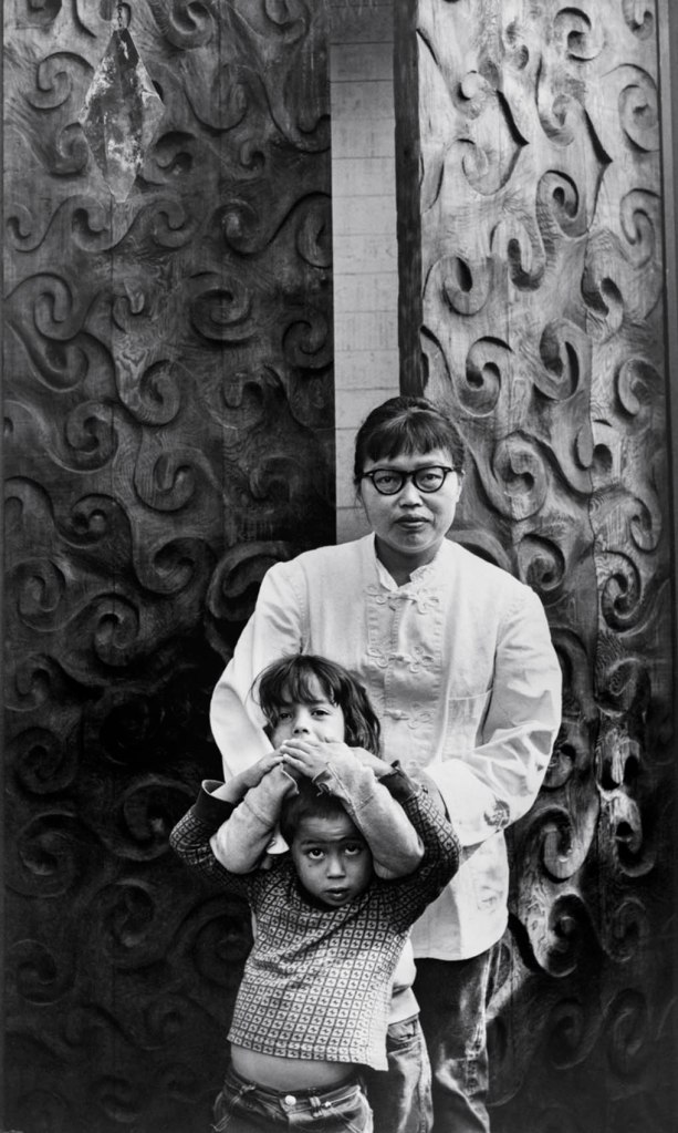 Joan Pearson Watkins (American, 1924-2013) 'Ruth Asawa with her children Addie and Paul in front of Doors (S.528, Carved Redwood Doors for Ruth Asawa’s Home), at her home in San Francisco' c. 1965 Joan Pearson Watkins (American, 1924-2013) 'Ruth Asawa with her children Addie and Paul in front of Doors (S.528, Carved Redwood Doors for Ruth Asawa’s Home), at her home in San Francisco' c. 1965