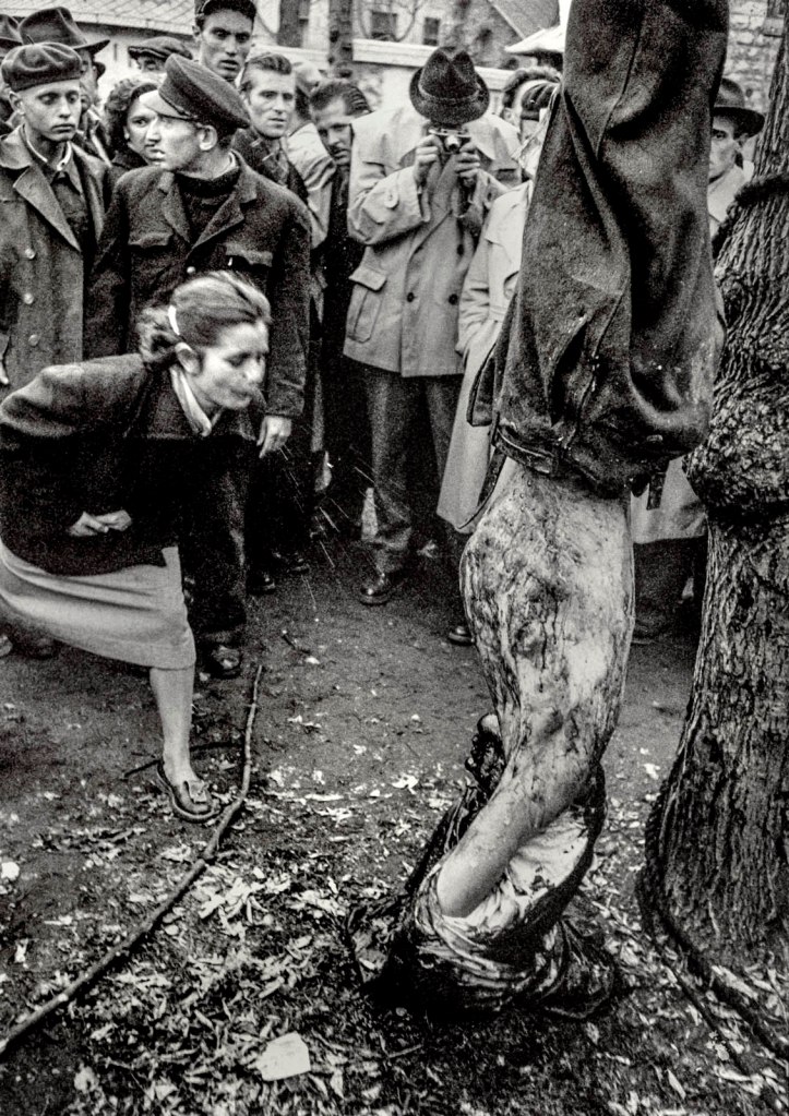 John Sadovy (English born Czech, 1925-2010) 'Woman spits in contempt on the body of a suspected AVO police agent' Hungary October 1956